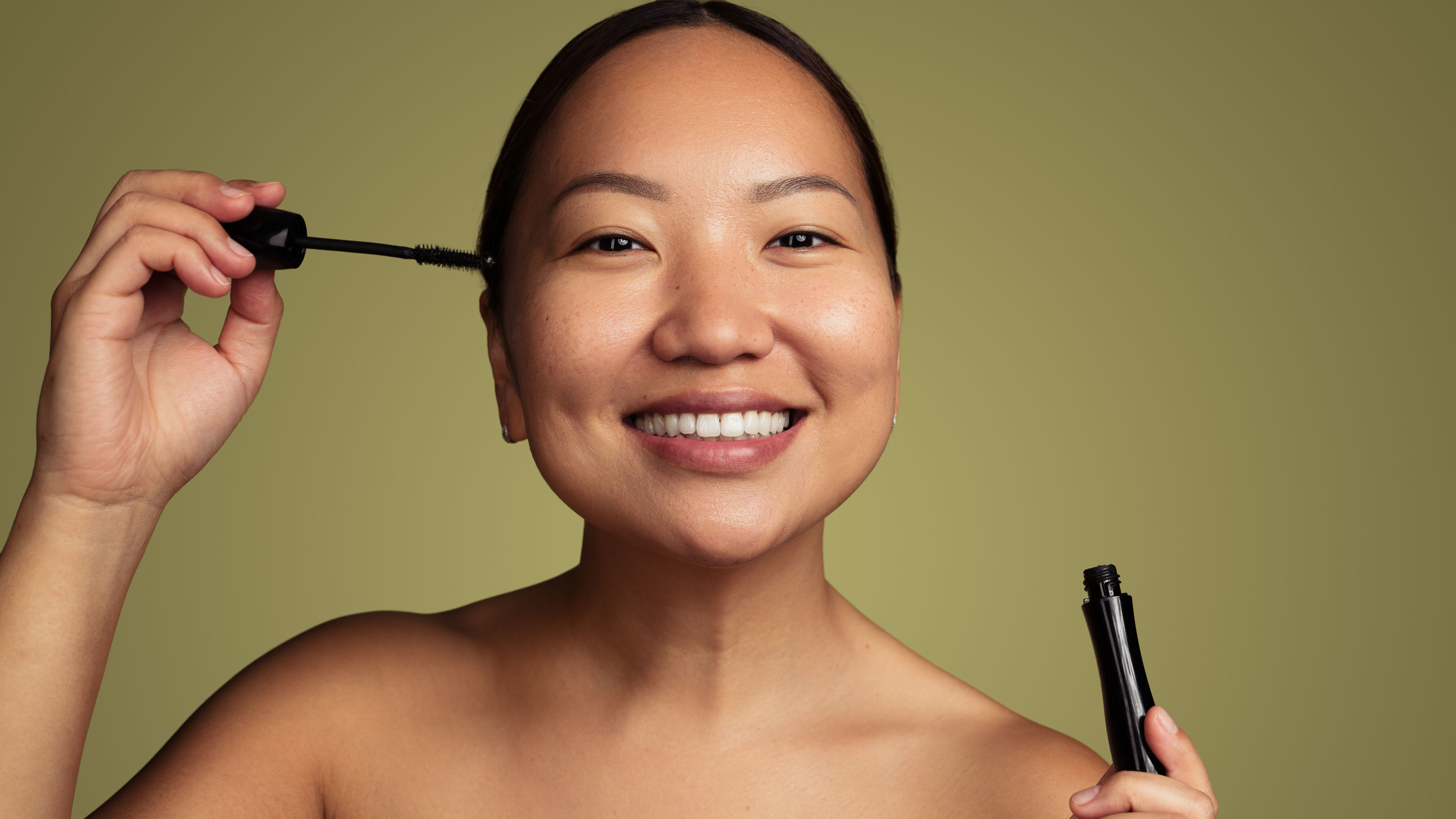 A woman applying mascara