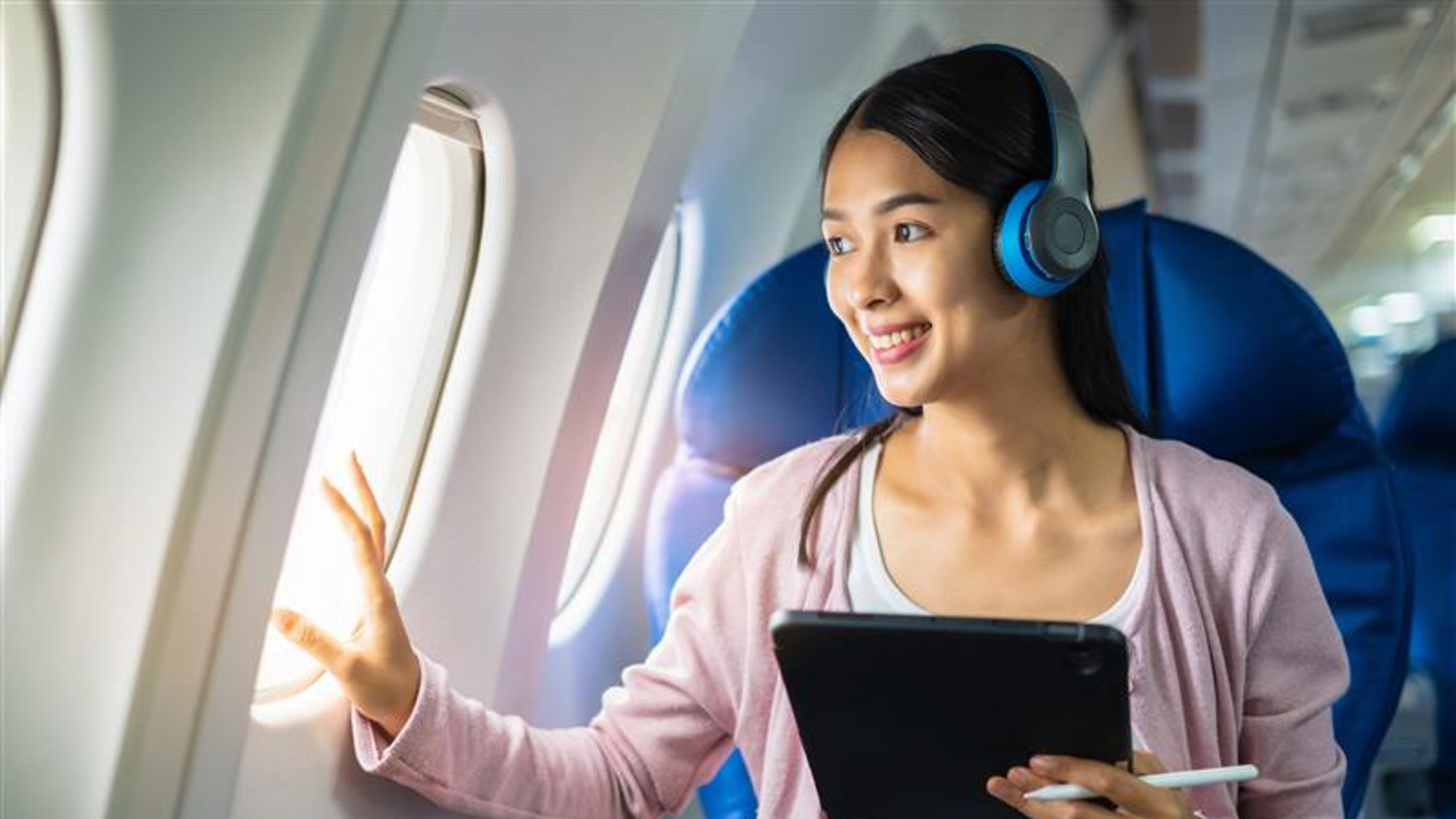 Aeroplane, travel and portrait of working on a laptop computer and smartphone while sitting in an aeroplane.