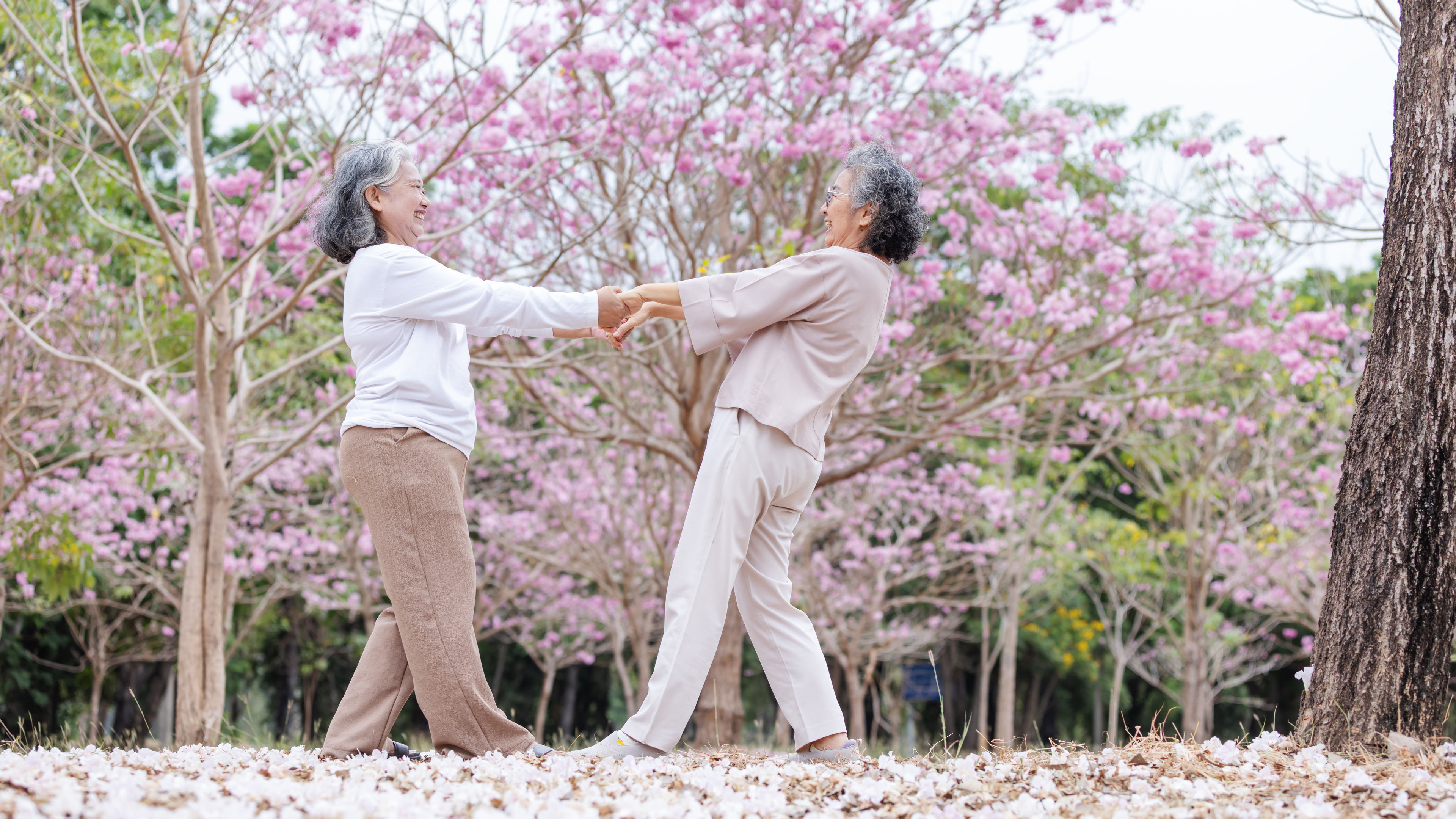 Two women holding hands in a flower garden